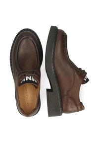 Scarpe in pelle marrone con punta arrotondata, suola in gomma nera e lacci decorativi. Presentano una banda con logo bianco al colletto.