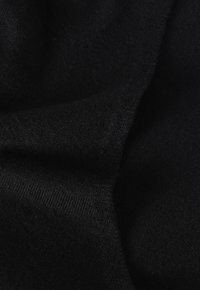 Tessuto nero a maglia con una consistenza morbida, che mostra leggere e sottili variazioni nella trama e nello spessore. Senza motivi o ornamenti notevoli.