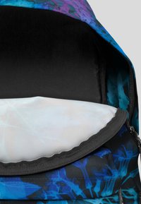 Plecak ma wielokolorowy, abstrakcyjny wzór kwiatowy w odcieniach niebieskiego i fioletowego na trwałym materiale. Wnętrze jest w jasnym kolorze i posiada zamek błyskawiczny.