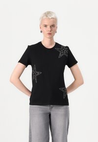 Black short-sleeve T-shirt with silver star appliqués on the front. Made of a soft, stretchy material. Round neckline and slim fit.