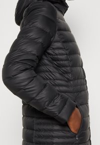 Sort polstret jakke med en blank finish, har hætte, lynlåslommer og en quiltet tekstur med vandret syninger.