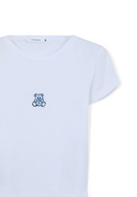 T-shirt bianca in cotone con maniche corte, caratterizzata da un piccolo ricamo di un orsetto blu sul petto. Classico scollo rotondo.