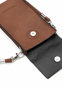 Hnědá kožená peněženka s černým koženým interiérem, s uzávěrem na patent, stříbrnými detaily a odnímatelným popruhem. Viditelné texturované povrchy.