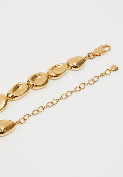 Bracelet en or avec des maillons ovales réfléchissants au toucher lisse. Comprend un fermoir et une extension de chaîne pour un ajustement de taille.