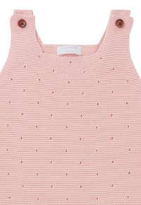 Strickoverall in Rosa mit kleinen, erhöhten Punkten, ausgestattet mit Holzknöpfen an den Trägern. Glatte Textur mit einem einfachen, funktionalen Design.