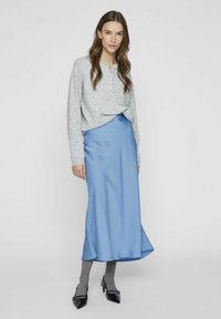 Siva dolgimi rokavi s sponkami, v kombinaciji z modrim satenskim krilom, sivimi nogavicami do kolen in črnimi čevlji s peto. Preprost in eleganten dizajn.