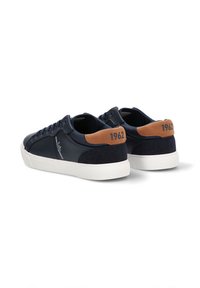 Zapatillas de cuero navy con acentos en ante marrón, suela de goma blanca y logo bordado. Cuenta con un collar acolchado y un diseño con cordones.