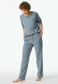 Gray pajama set with long-sleeve top featuring ribbed accents and loose-fit pants. Drawstring waistband with orange details. Soft texture.