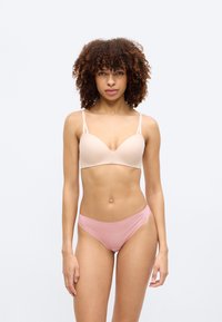 Ελαφριά μπεζ μαξιλαρωτό σουτιέν με ρυθμιζόμενους ιμάντες και λείο ύφασμα, σετ με απαλό ροζ μπικίνι με χαμηλή μέση. Απλός σχεδιασμός, χωρίς σχέδια.