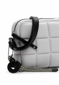 Borsa grigia trapuntata con tracolla in pelle nera, chiusura a zip e dettagli testurizzati. Presenta un cordino intrecciato e un'etichetta circolare.