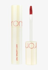 Tienne à lèvres liquide avec un tube cylindrique jaune brillant comportant un texte rouge. Comprend un applicateur transparent avec une pointe douce et duveteuse.