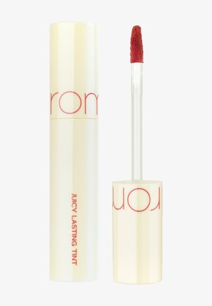 Tinta labbra liquida con un tubo cilindrico giallo lucido caratterizzato da testo rosso. Include un applicatore trasparente con una punta morbida e pelosa.