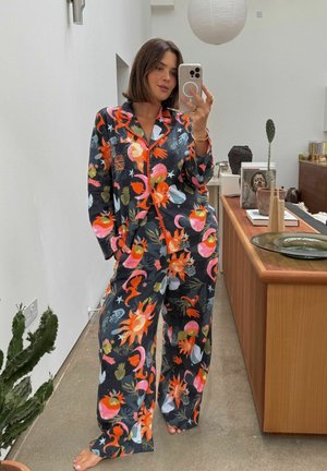 Tumedas kangast lillemustriga pidžaamakomplekt, millel on lõdvestunud lõige ja ääri mööda kontrastne ääris.