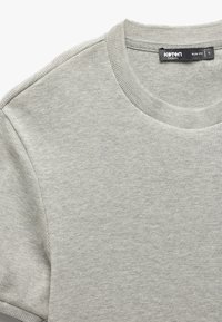Jasnoszara, krótko rękawowa koszulka z prążkowanej bawełny, z okrągłym dekoltem i dopasowanym krojem. Metka z napisem "Koton Casual, Slim Fit, L."