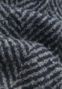 Getextureerde wollen stof in donker marineblauw en grijs, met een chevronpatroon en een zachte, pluizige textuur.