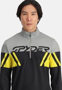 Halve rits sportieve pullover in grijs, zwart en neon geel. Voorzien van een gedurfde Spyder-logo, contrasterend kleurblokontwerp en een zachte textuur.