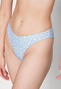 Parte de baixo de biquíni azul claro com padrão de margaridas, apresentando um corte baixo e textura suave. Projetada com bordas sem costura para conforto.