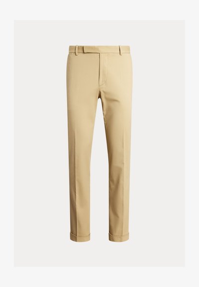 Khaki chinos vyrobené z hladké bavlněné tkaniny, s přiléhavým střihem, předními puky a náplety na kotnících pro zúžený vzhled.