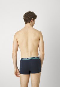 Dunkelblaue Boxer-Briefs mit enger Passform, weichem Material und einem kontrastierenden Bund, der das Logo "JACK & JONES" in Weiß und Türkis zeigt.
