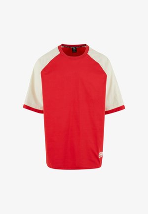 T-shirt en coton rouge avec des manches raglan crème. Présente un col rond et un liseré contrasté aux manches. Détail du logo sur le côté inférieur.