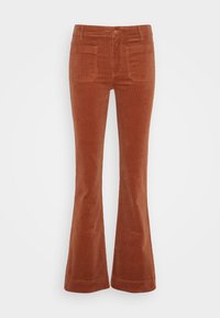 Pantalones de pana acampanados en naranja quemado, con cintura alta, bolsillos frontales y un acabado suave y texturizado.