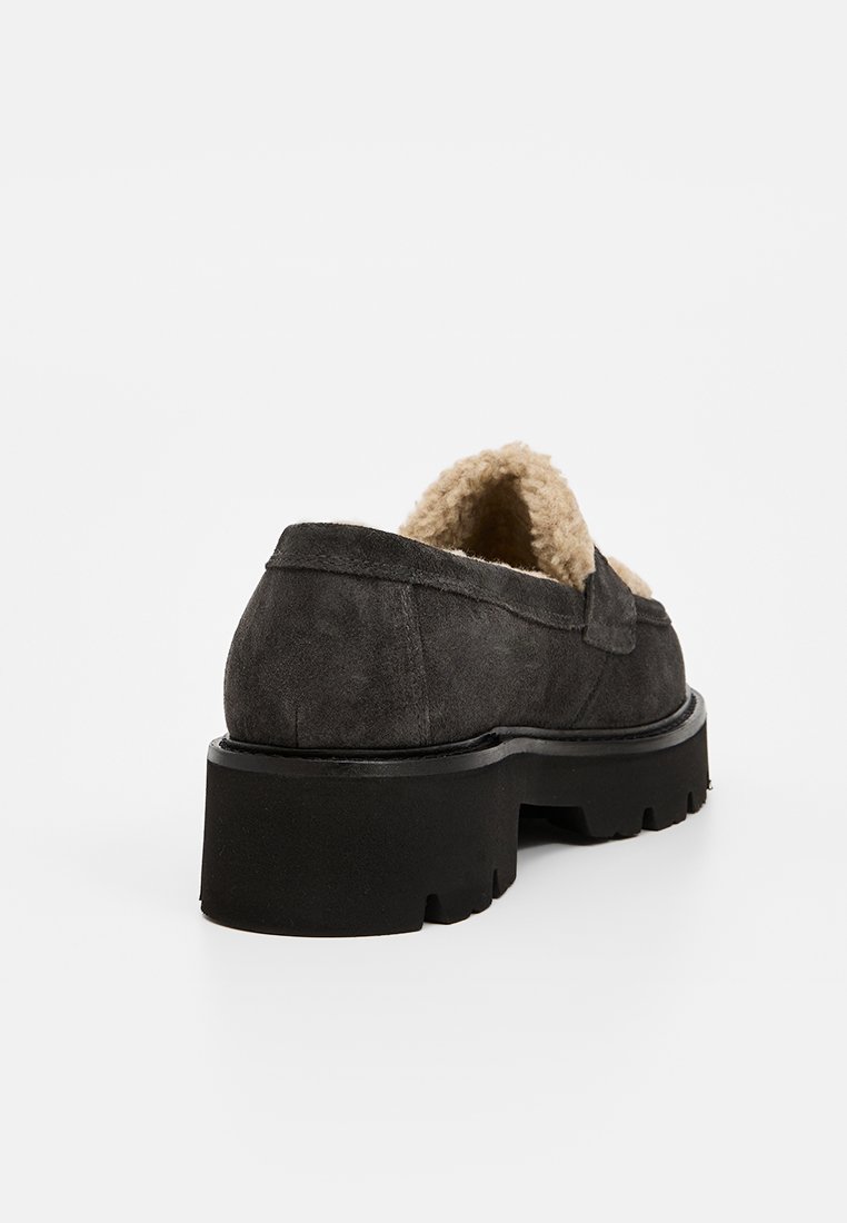 Grauer Wildlederschuh mit texturiertem, Kunstfellfutter. Massive schwarze Gummisohle mit Profil, runder Form und kontrastierenden Nähakzenten.