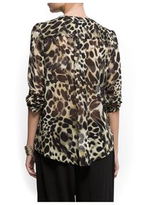 Blouse transparente avec un motif léopard dans des teintes de marron, beige et noir ; elle possède des manches longues retroussées et un dos droit.