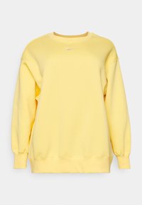 Gul sweatshirt i mjukt tyg, med långa ärmar och rundad halsringning. Litet vitt Nike-logotyp på bröstet. Avslappnad design.