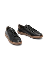 Black leather sneakers with a textured accent at the heel, round toe, and brown rubber sole. Features lace closure and perforated detailing.