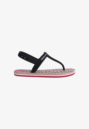 Sandalia infantil con tiras trenzadas negras y plantilla con estampado de leopardo en rosa, beige y negro, con suela rosa y blanca.