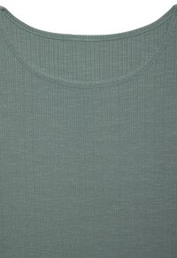 Ribani svijetlo tirkizni top s okruglim izrezom. Tkanina ima teksturirani izgled i suptilni sjaj, idealna za kombiniranje u slojevima.