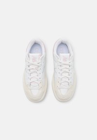 Zapatillas blancas con acentos en rosa claro, con una parte superior de cuero texturizado y sintético, puntera redondeada y diseño tradicional de cordones.