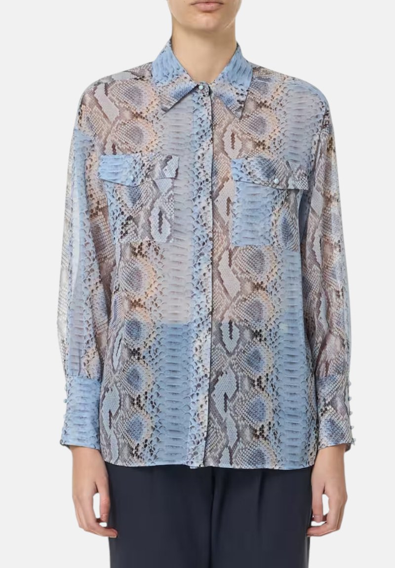 Blusa leggera e trasparente con stampa a serpente blu e marrone. Maniche lunghe, chiusura a bottoni sul davanti e due tasche sul petto con pattine.