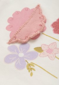 Tekstil med blomster mønstre med lyserøde og lavendel blomster. Dimensionerne inkluderer et lyserødt blad med tekstureret syning på en cremefarvet baggrund.