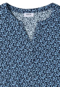 Chemise bleu marine avec motif de feuilles bleu clair, encolure ronde avec fente avant, et étiquette "CECIL" à l'intérieur du col.