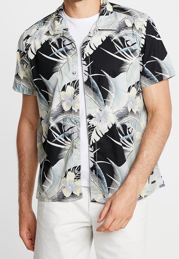 Camisa de manga corta con base negra y estampado floral tropical en tonos verdes, beige y blanco. Diseño de botones en el frente, ajuste relajado.