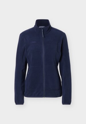 Laivastonsininen fleece-takki, jossa on täysipitkä etuvetoketju, pystokaulus, pitkät hihat, vetoketjulliset sivutaskut ja hillitty logo rinnassa.