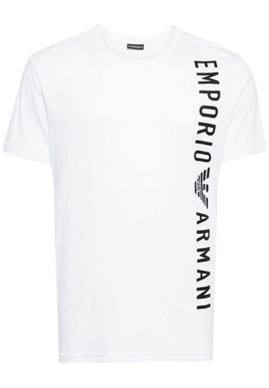 T-shirt bianco in cotone con scollatura a girocollo, maniche corte e stampa verticale del logo nero lungo il lato sinistro. Texture liscia.