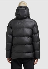 Czarna pikowana kurtka puchowa z wysokim kołnierzem i dużym kapturem. Charakteryzuje się pikowanym wzorem i gładkim, błyszczącym materiałem. Z regulowanymi mankietami.