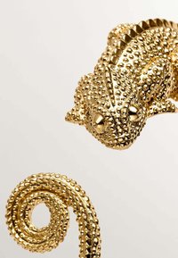 Escultura de camaleón dorado con una superficie texturizada y con cuentas, que presenta detalles intrincados y un diseño de cola rizada.