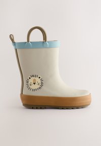 Stivale da pioggia beige per bambini con bordo azzurro chiaro, suola marrone, motivo faccia di leone e maniglie per tirare su sfondo semplice.