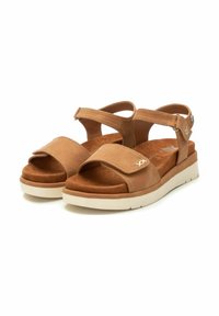 Sandalias de cuero marrón con dos correas anchas y una plantilla acolchada. Presentan una suela flexible de color claro y correas ajustables en el tobillo.