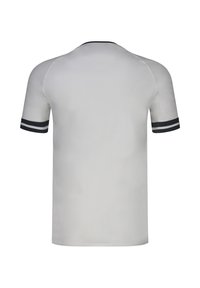 Chemise blanche unie à manches courtes avec des doubles rayures noires et blanches sur les poignets des manches et une bordure noire au niveau du col, vue de dos.