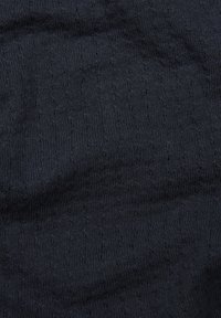 Ciemnogranatowa tkanina o teksturze, z jednolitym wzorem dzianiny, z małymi, równomiernie rozmieszczonymi dziurkami, tworzącymi subtelny efekt przestrzenny.