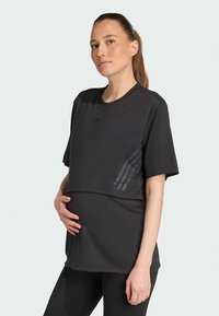 Schwarzes athletisches T-Shirt aus atmungsaktivem Stoff, mit kurzen Ärmeln und geschwungenem Saum, versehen mit dezenten grafischen Akzenten auf einer Seite.