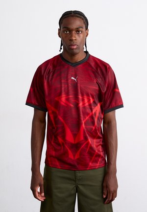 Rode sportieve shirt met een geometrisch patroon, korte mouwen, v-hals en zwarte accenten. Gemaakt van lichtgewicht, ademend materiaal.