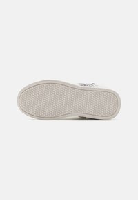 Vita sneakersula med en strukturerad, bikake-mönster. Kanten är något rundad, vilket ger ett lätt och flexibelt utseende.