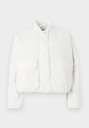 Veste blanche courte en tissu léger, dotée d'un col haut, de deux poches à rabat à l'avant et d'une surface texturée.