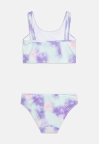 Dvodijelni bikinI set u tie-dye uzorku s pastelnim ljubičastim, plavim i ružičastim bojama. Gornji dio ima široke trakice i atletski kroj.