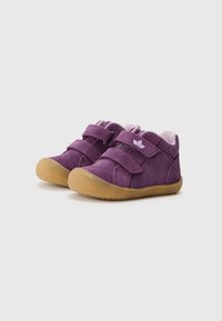 Sapatos de camurça roxos com duas tiras de Velcro, bicos arredondados e sola de borracha bege. O forro macio oferece conforto e apoio aos pés.